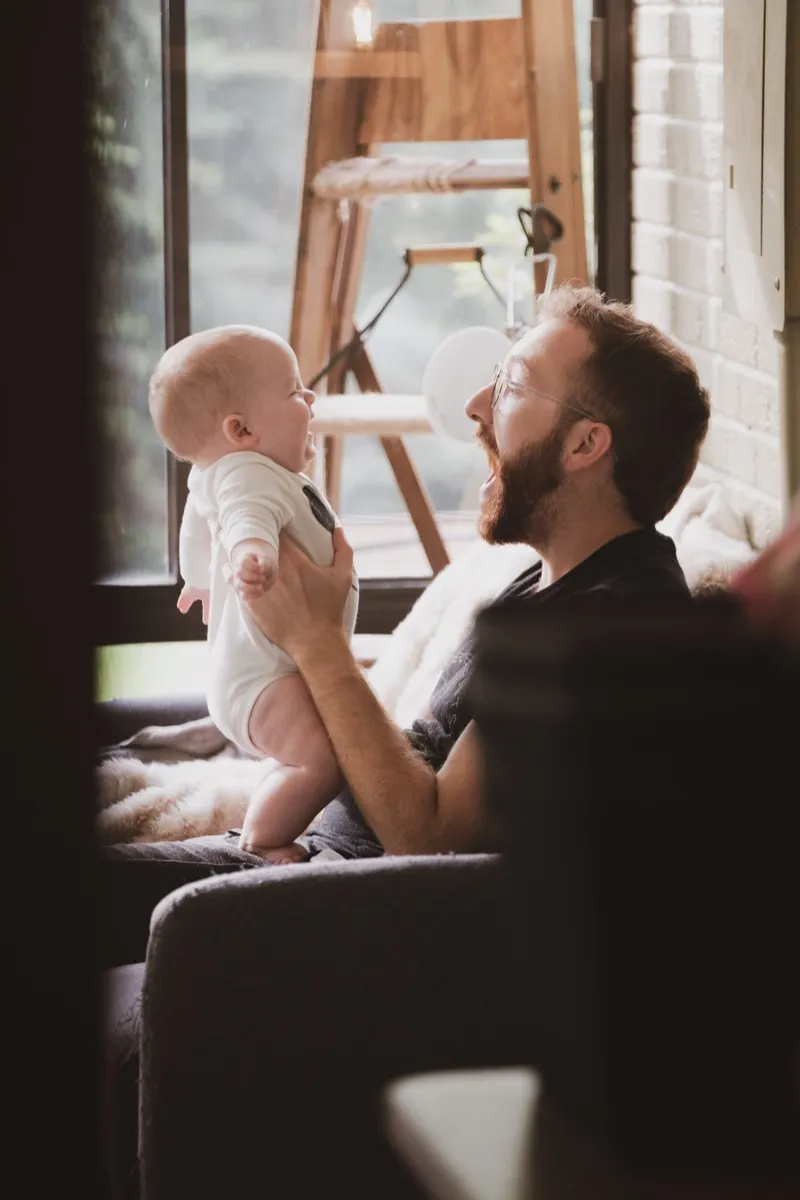 Kevin holding his young son at home