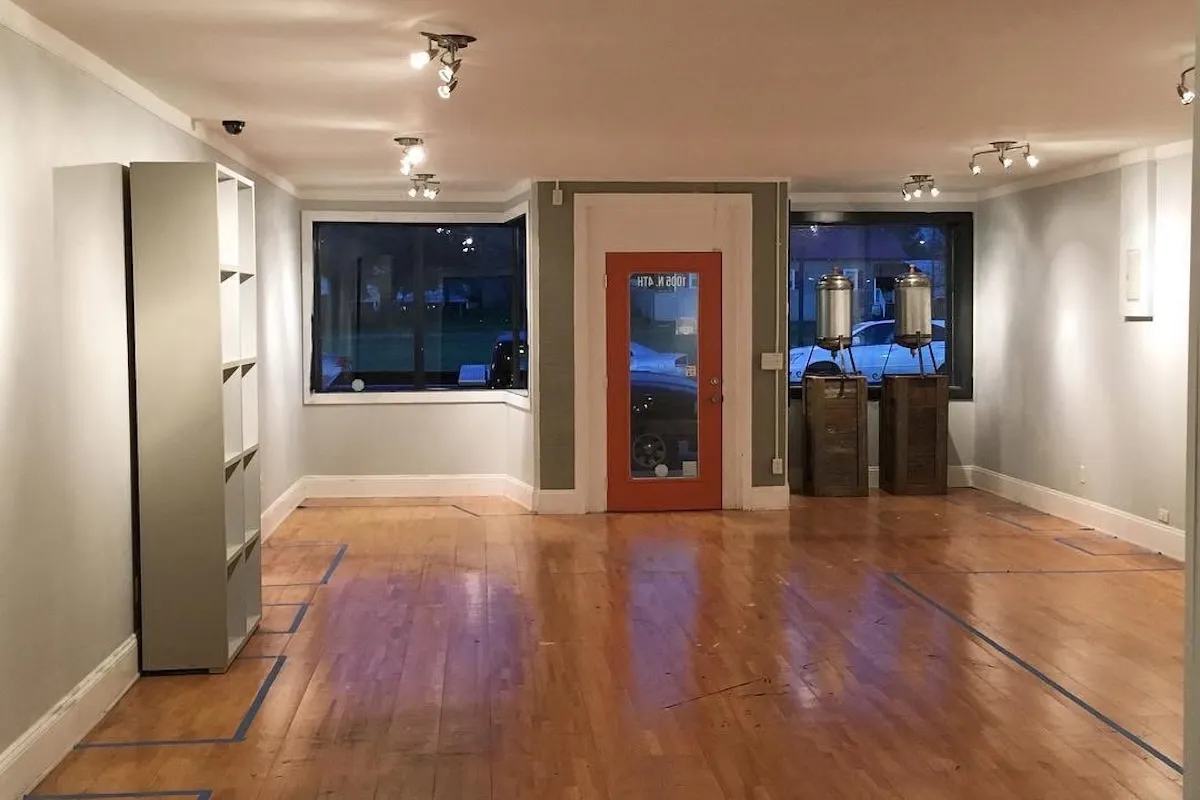 A small shop interior with an orange front door